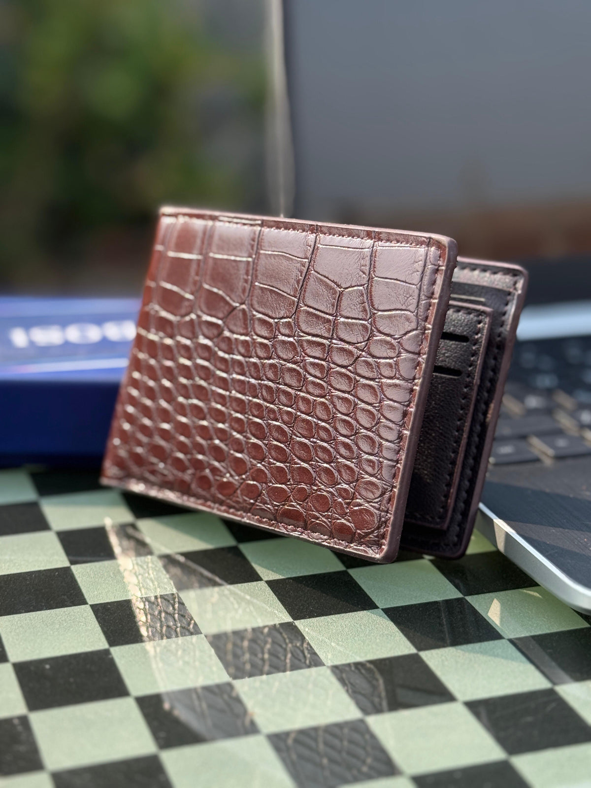 Black and dark brown crocodile leather wallets side by side